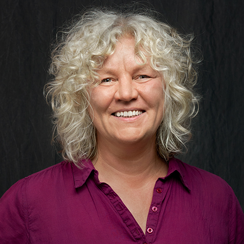 Dozentin mit blonden Locken lächelt in die Kamera