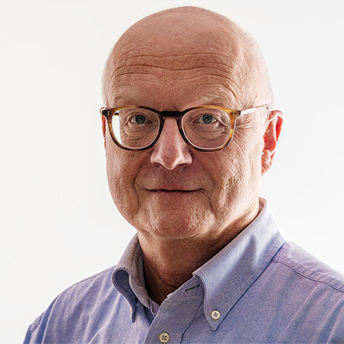 Dozent mit Brille blickt in die Kamera